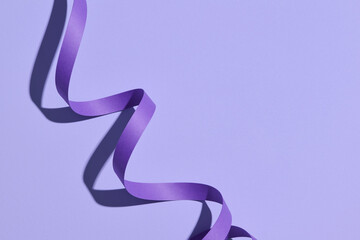 Spiral ribbon on color background with shadow