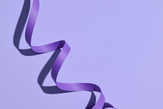 Spiral ribbon on color background with shadow
