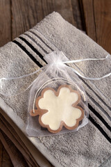 Handmade aromatic sachet on gray towel. Soy wax sachet in form of clover leaf. Handmade eco-friendly gift
