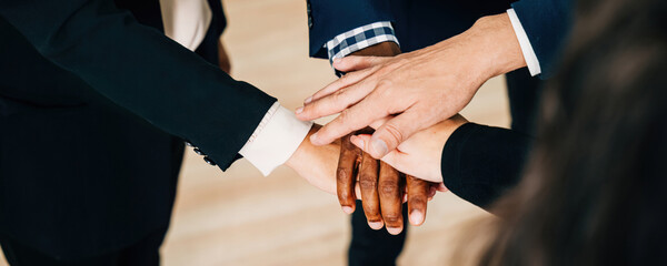 An above view of a diverse business group holding hands in a circle. This act of teamwork and...