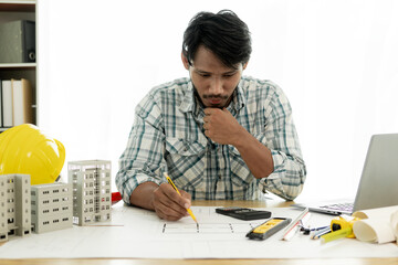 Architects studying floor plans, serious civil engineers working with documents on real estate construction, and professional foremen in home improvement: