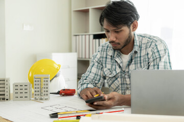 Architects studying floor plans, serious civil engineers working with documents on real estate construction, and professional foremen in home improvement: