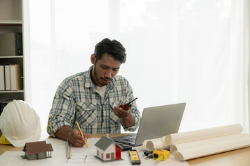 Architects studying floor plans, serious civil engineers working with documents on real estate construction, and professional foremen in home improvement: