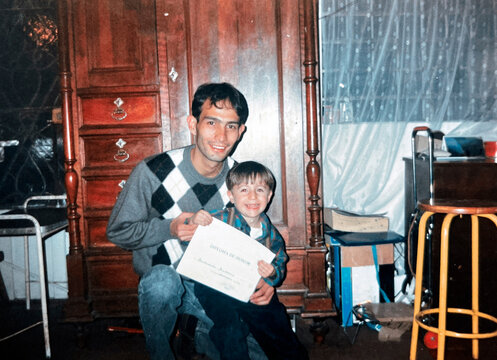 Father and son holding a diploma