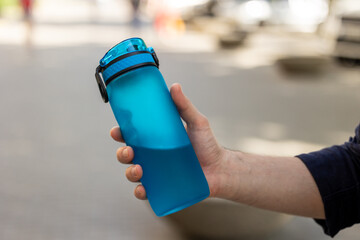 A person is holding a water bottle