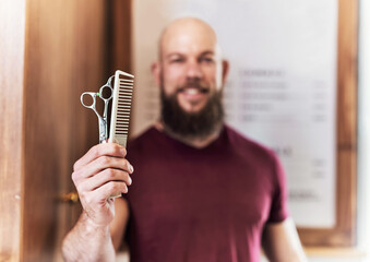 Hair care, tools and portrait of man in barbershop with scissors, comb and skills at trendy small...