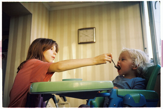 The kids are messing around with a pancake at the table