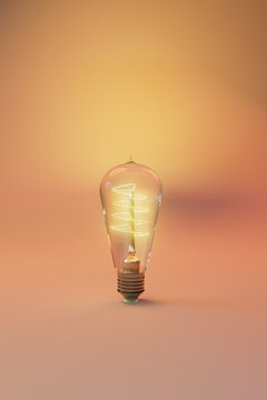 Conceptual Edison Bulb with Glowing Filament on Soft Background