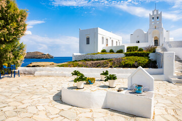 Courtyard of Chrysopigi monastery and beautiful white church with sea in background, Sifnos island,...