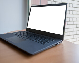 Fototapeta premium modern blank screen laptop on a wooden desk, screen for mockup. natural light.