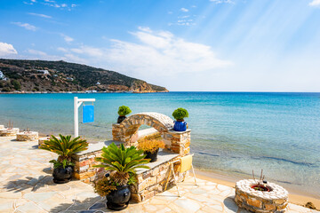 Coastal promenade along azure sea and sandy beach in Platis Gialos village, Sifnos island, Greece