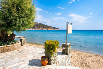 Coastal promenade along azure sea and sandy beach in Platis Gialos village, Sifnos island, Greece