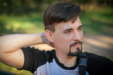 A guy poses outdoors in a park. Summer days, summer mood.