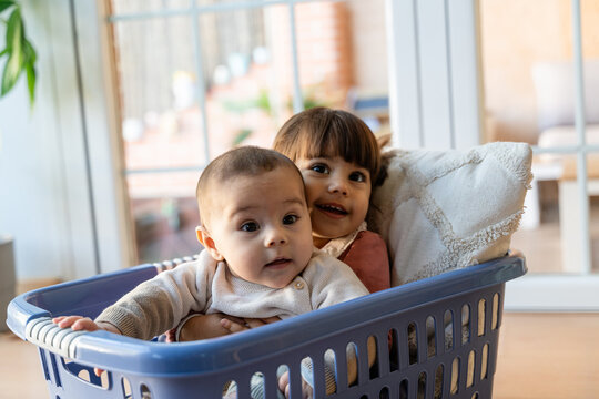 Siblings Smiling in Laundry Basket