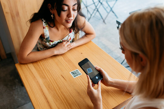 Women scanning a QR Code in a cafeteria