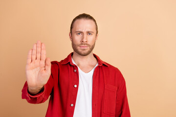Photo of nice young man arm show stop wear red shirt isolated on beige color background