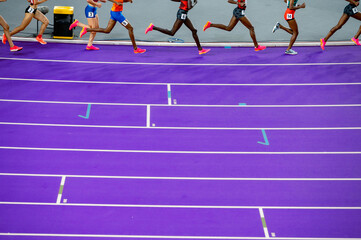 Legs of female endurance athletes on purple Paris Track. Photo for sport track and field summer game in Paris 2024. Athletics and Games