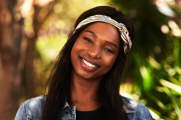 Black woman, portrait and happy at park in nature with fashion, casual style and trendy outfit in...