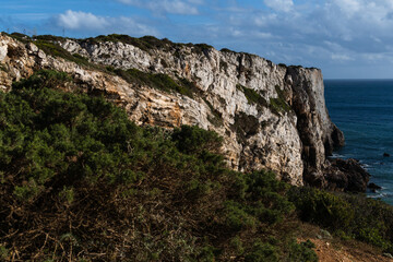 Naklejka premium Praia do Beliche beach in Sagres, Algarve, Portugal. Sunny day with surfers in the sea