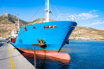 Cargo ship anchoring in Kamares bay port with mountains in background, Sifnos island, Greece