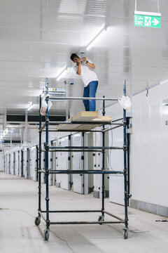 Man on stand installing security camera
