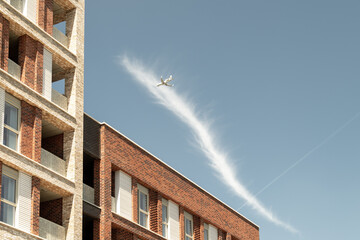 Airplane flying over newly built apartments