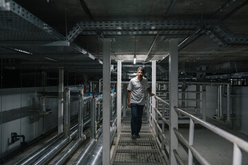 Male technician examining ceiling of storehouse