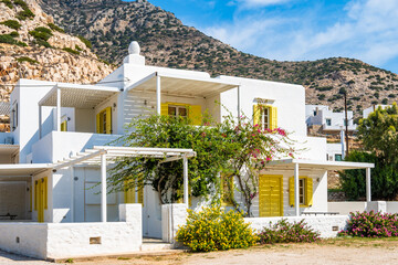 Typical holiday apartment building for rent with yellow window shutters in Kamares village, Sifnos...