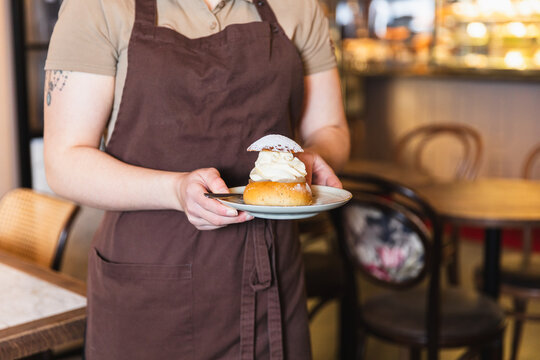 Waiter holding a Swedish semla cake 