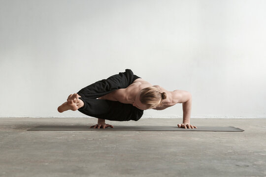 Flexible man doing Two Legged Sage Koundinyas pose
