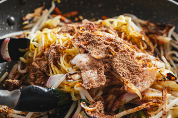 炒めた焼きそばに粉末ソースを加える