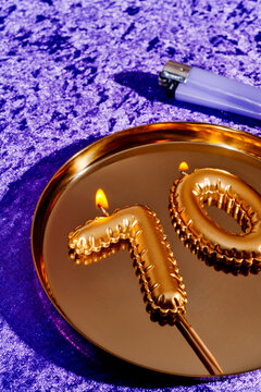 lit number-shaped candles forming the number 70