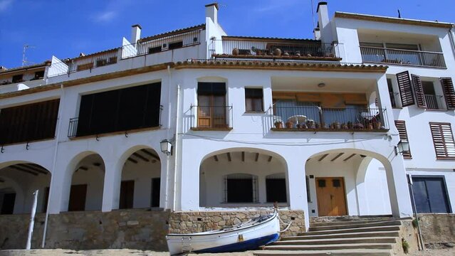 Partial view of the promenade with arcaded porch bordering the beach of Port Bo. Calella de Palafrugell, Costa Brava, Catalonia, Spain.