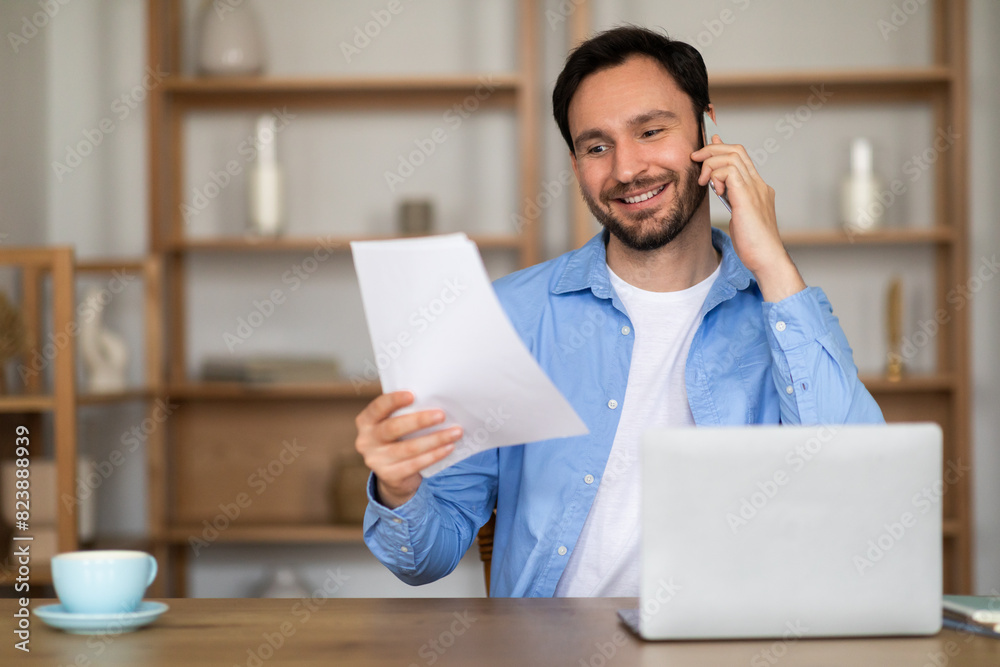 Aufkleber A man is sitting at desk while talking on the phone, holding a piece of paper in his hand. He appears focused as he communicates using the phone and glances at the paper intermittently.