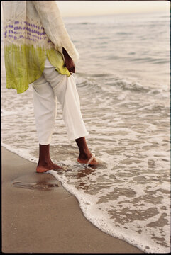 Woman touching sea water with foot