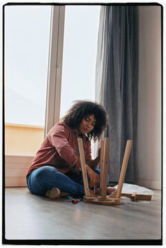 Woman assembling furniture at home