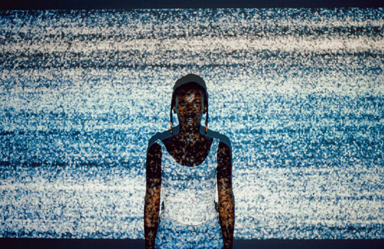 Woman posing in noise projected on her