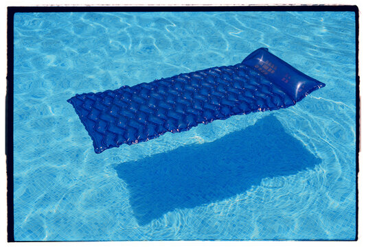 Air mattress floating on water in pool