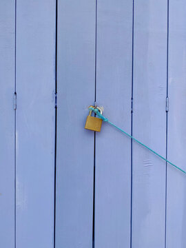 Rusty padlock on a blue wooden door.
