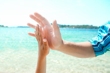 A Hands of a happy parent and child in nature by the sea on a journey background