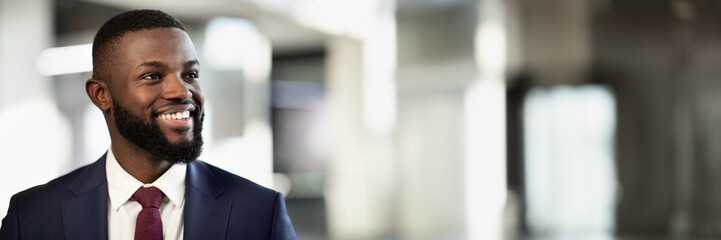 Closeup portrait of cheerful african american young businessman posing at office building, handsome...