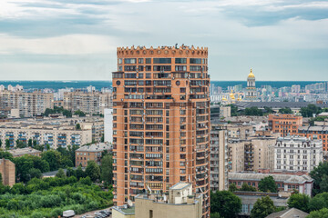 A modern highrise building stands in an urban cityscape with a historical background
