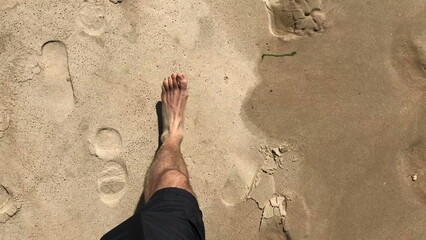 POV of person legs walking at the beach