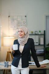 A woman in a business suit is holding a coffee cup and smiling. Concept of professionalism and confidence