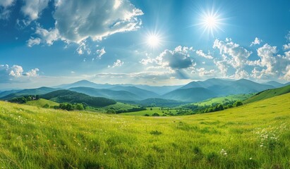 Fototapeta premium Beautiful summer landscape with green grass, mountains and blue sky with sun rays