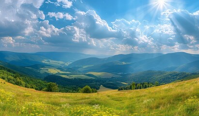 Beautiful summer landscape with green grass, mountains and blue sky with sun rays