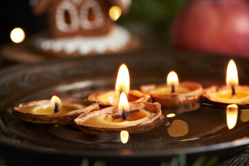 Christmas candles made of bees wax and nut shells floating in a bowl of water