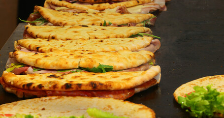 Flatbreads filled with cured meats and vegetables called SPIANATA BOLOGNESE in Italian cooked on a hot griddle typical dish of CENTRAL ITALY cuisine © ChiccoDodiFC