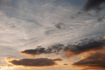 Dramatic sunset sky with orange and grey clouds, evening atmosphere