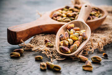 Roasted and peeled pistachios in wooden spoons
